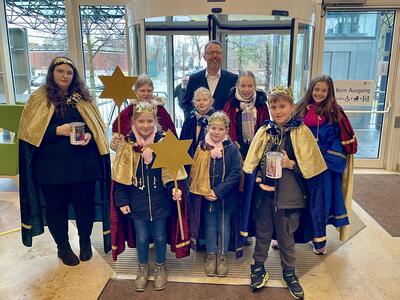 Sternsinger und Landrat Alexander Tönnies stehen im Foyer der Kreisverwaltung.