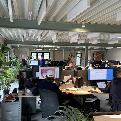 Personen an ihrem Arbeitsplatz in einem Gro&szlig;raumb&uuml;ro