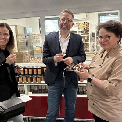 Sylke Wienold pr&auml;sentiert WInTO-Gesch&auml;ftsf&uuml;hrerin Claudia Flick und Landrat Alexander T&ouml;nnies eine Auswahl ihrer Pralinen.
