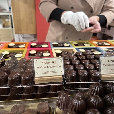 Ein Blick in die Theke zeigt viele verschiedene Sorten Pralinen.