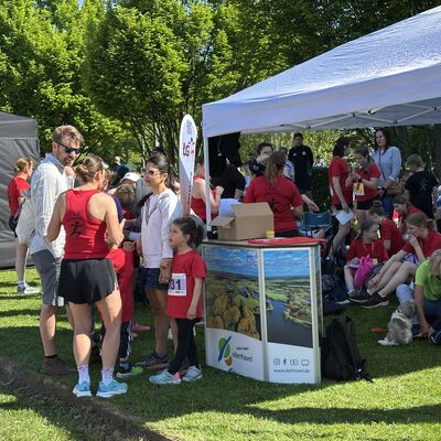 Zahlreiche junge und &auml;ltere L&auml;uferinnen mit roten T-Shirts und stehen am Stand vom Landkreis Oberhavel.