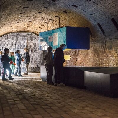 Menschen stehen in einem Museumsgew&ouml;lbe aus Backstein.