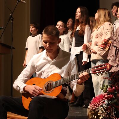 Jungen und M&auml;dchen im Chor auf einer B&uuml;hne.