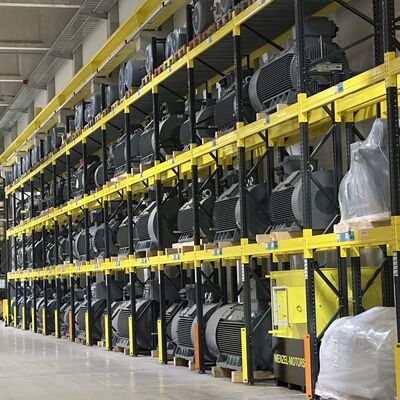 Hunderte Elektromotoren stehen gestapelt in riesigen Regalen einer Fabrikhalle.