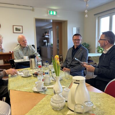 Vier M&auml;nner, davon zwei Senioren, sitzen an einer Kaffeetafel in einer Senioreneinrichtung des Arbeitersamariterbundes Leegebruch.